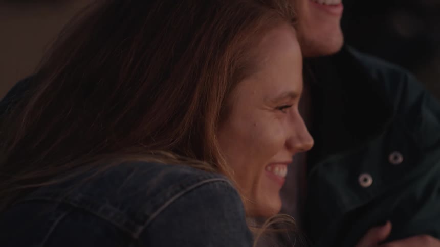 Man and woman smiling and talking while embracing