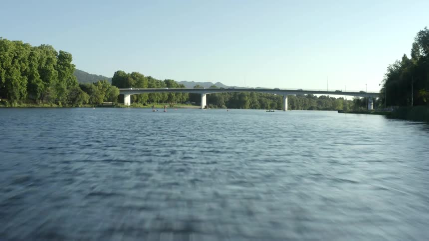 A traffic bridge spanning a river in the countryside during the day