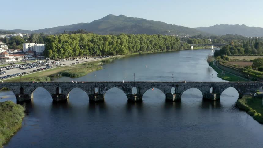 Aerial view of a bridge over a river near a small town close to the mountains at morningtion