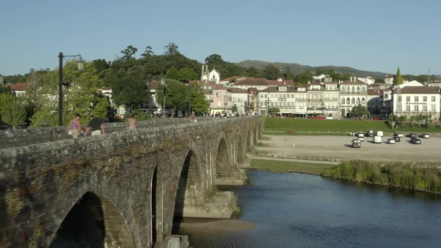 People walk across the stone bridge