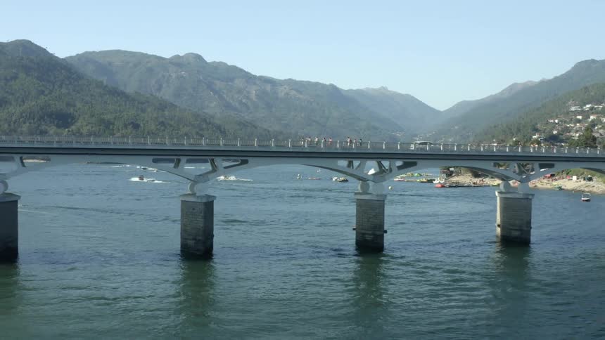 A bridge leads to a small coastal town on the hills