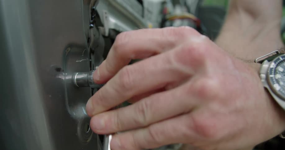 A person is using a wrench on their car door