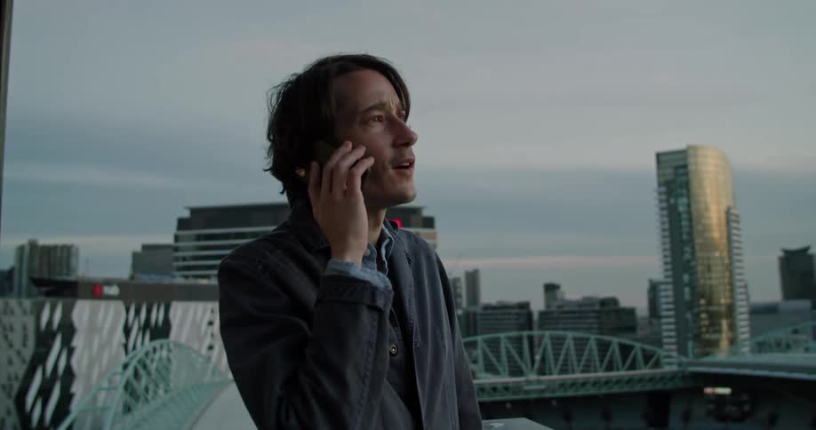 A man standing outside talking on a phone