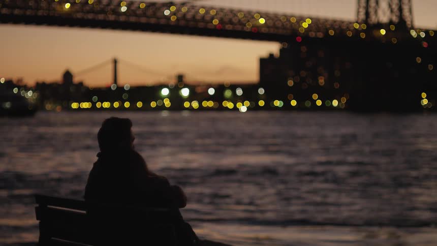 A couple sits close on a river at sunset