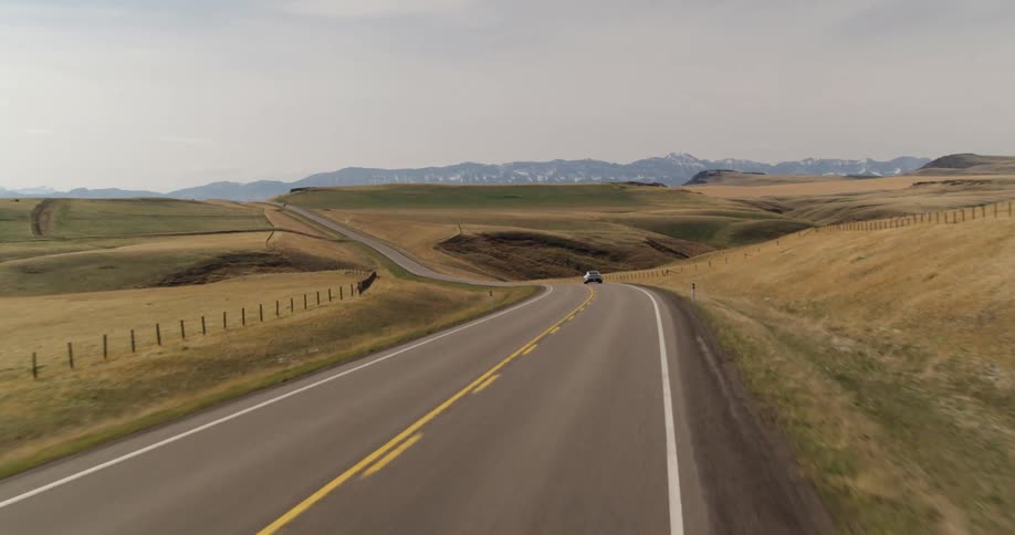 electric sports car drives on highway through hills
