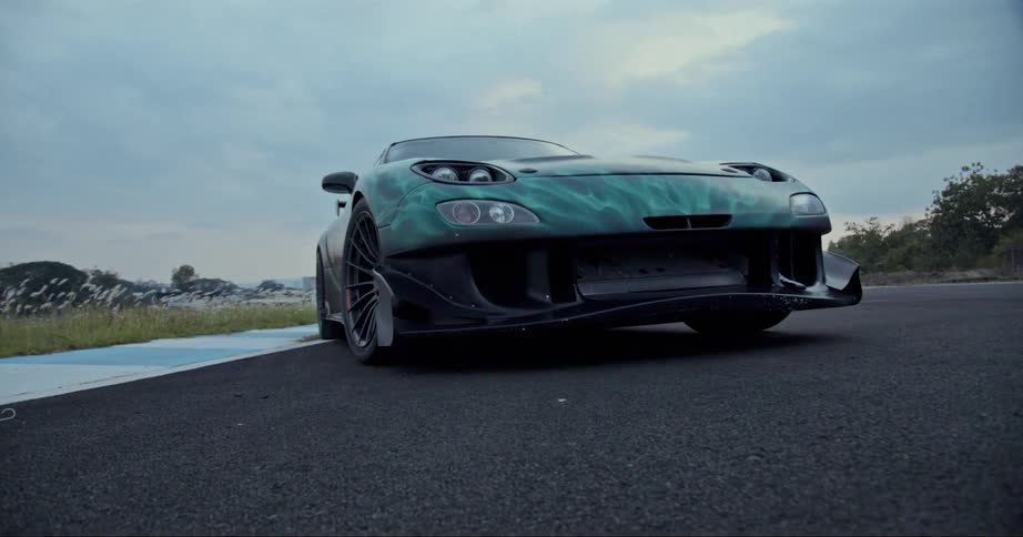 A green sportscar is parked on a road
