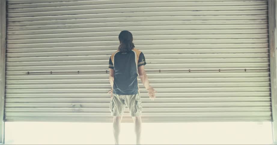 A man is lifting a garage door from the inside