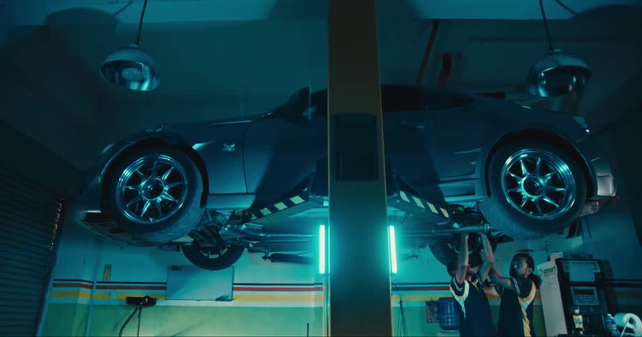 Two mechanics working on a car