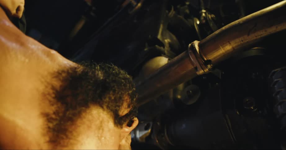Man with beard stands looking over large machinery