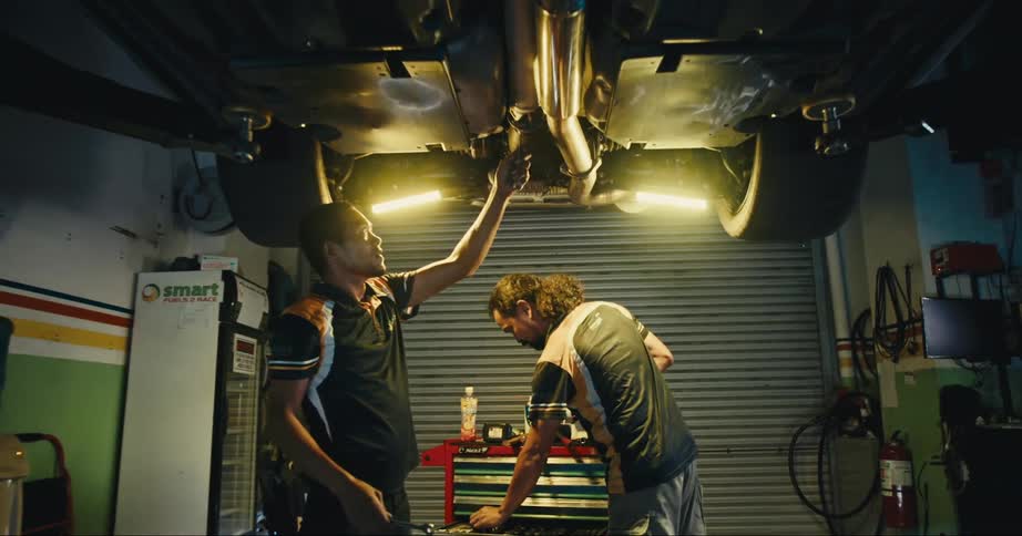 Mechanics looking at car