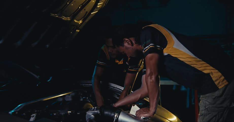 Two people working on an engine together