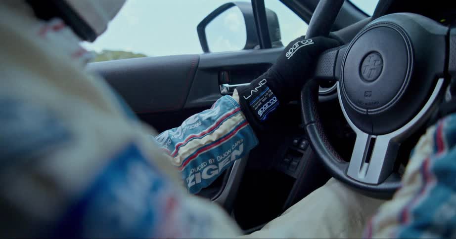 A race car driver is steering a vehicle