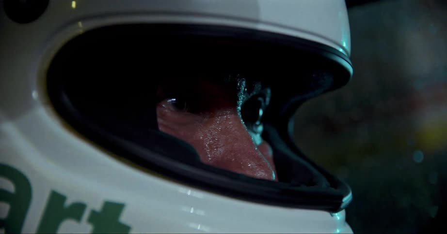 A person in a vehicle with a helmet
