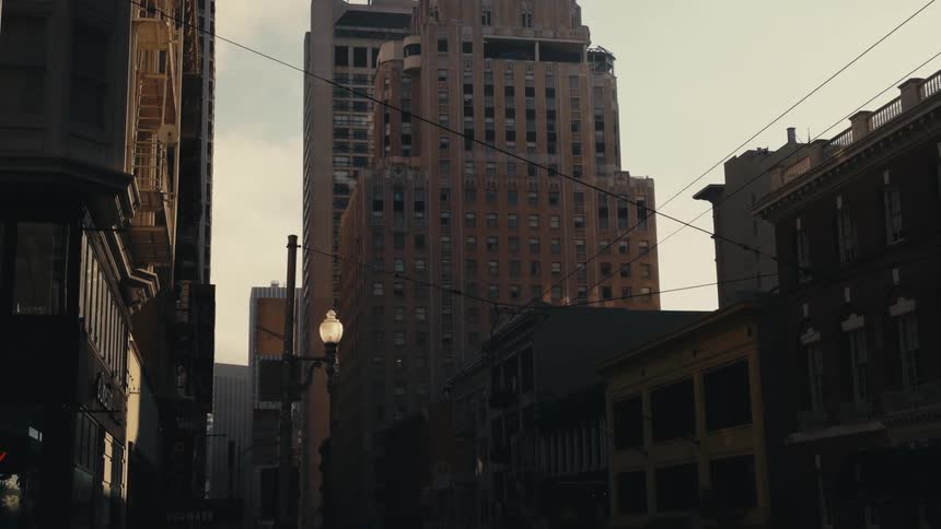 Tall old skyscrapers on the city near the empty streets at morning
