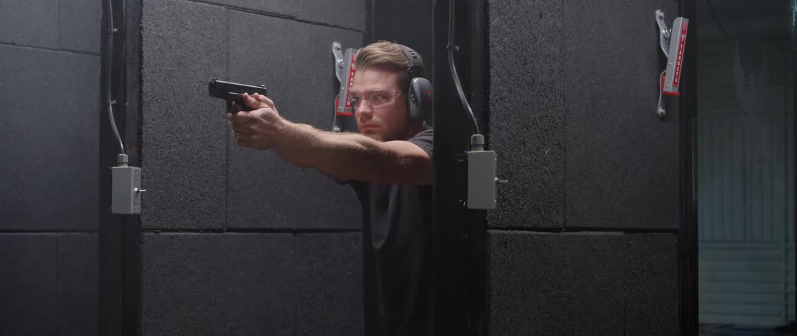 A man loads a gun and fires at a target range