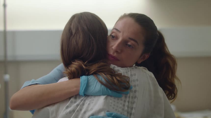 Nurse consoles a patient with a hug in a hospital room