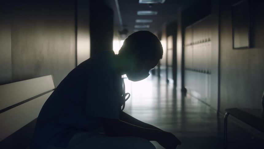 A person is sitting in the empty hallway