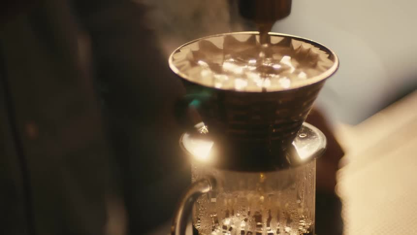 Hot water pouring inside a filter making a cup of fresh hot coffee