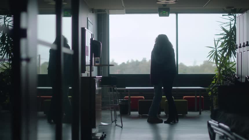 A silhouette of two women hugging with a table chairs and a window in the background