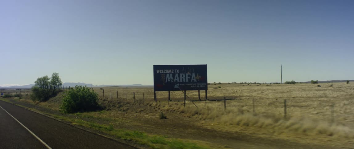 Sign on a field at the side of a rural road at daytime