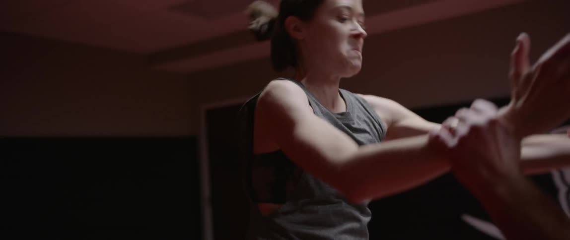 Woman sparring with a padded partner