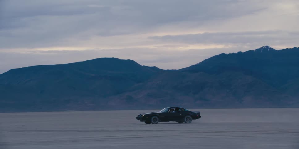 A car speeds past the mountain range