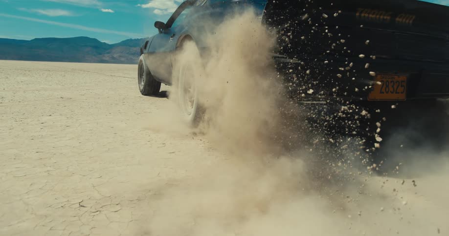 A car doing a burnout on the dirt
