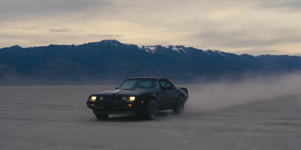 A car driving fast on a dry lake bed