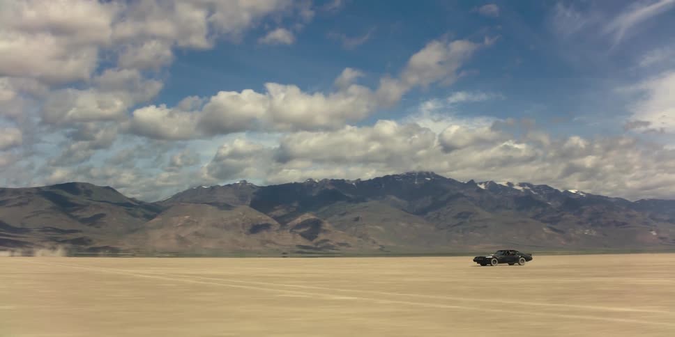 A car drives in the empty desert