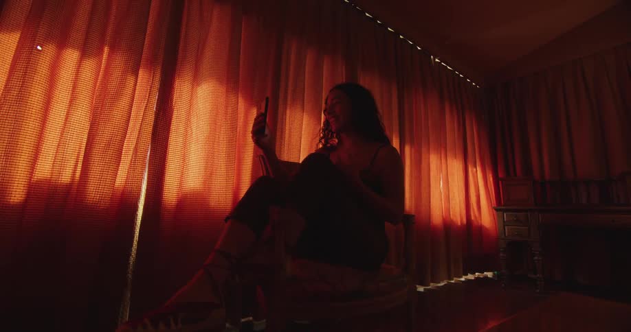A woman sitting in a room talking on a phone