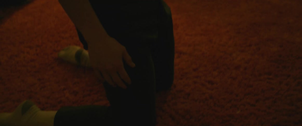 Man dances on carpet in room near windows surrounded by houseplants