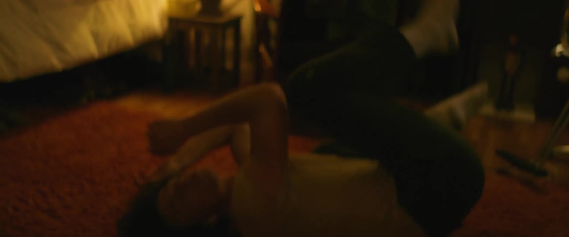 A boy begins a dance on his bedroom floor swaying and flipping into a handstand landing on his bed