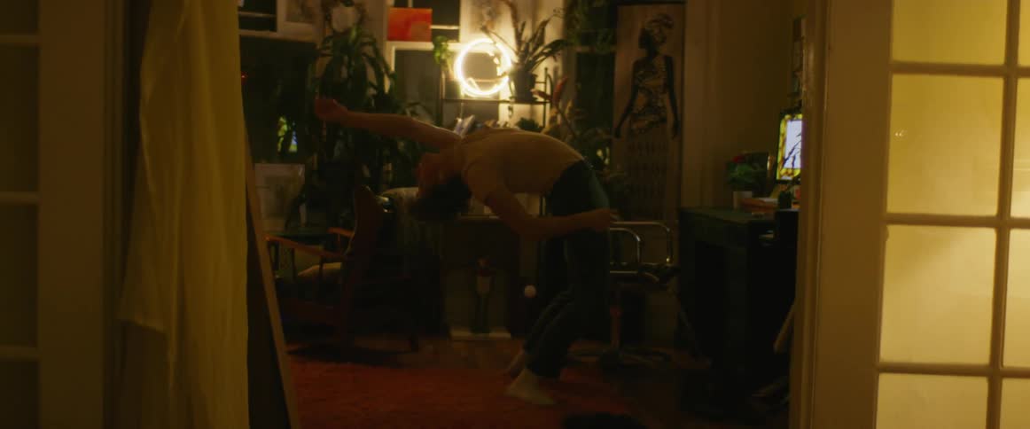 Young man dancing inside a dimly lit room at night