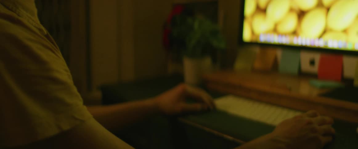 Young man thinking while working on a computer at home
