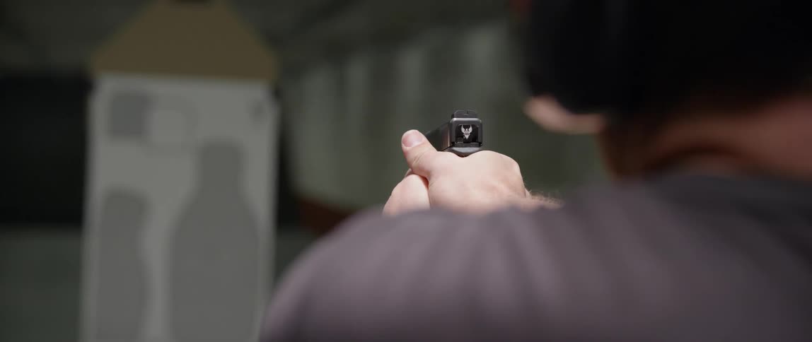 Man firing a pistol at a target