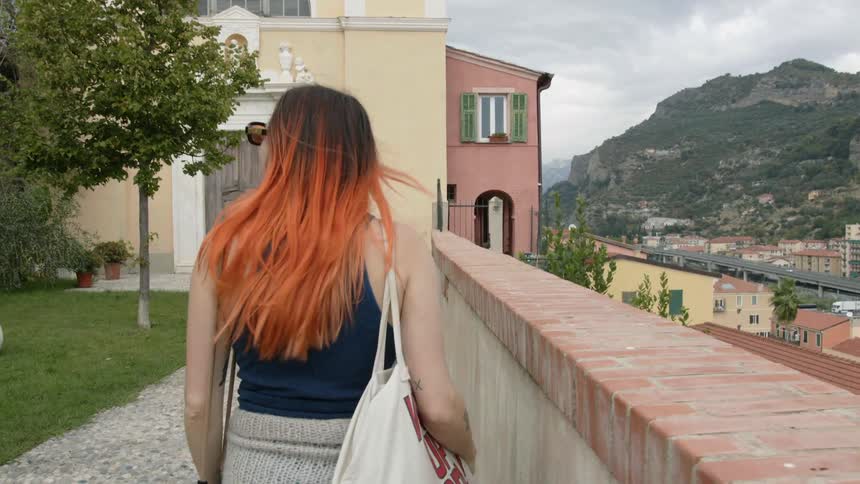 A woman is walking around viewing the village