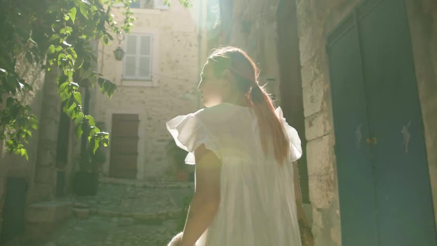 A woman walking in an alley with plants