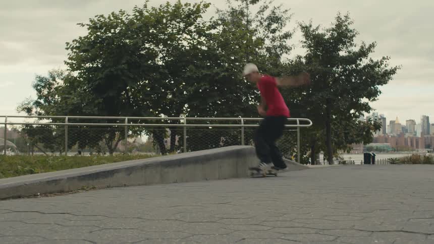 A boy rides his skateboard and does a jump