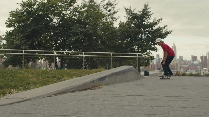 A skater does a trick on a concrete curb