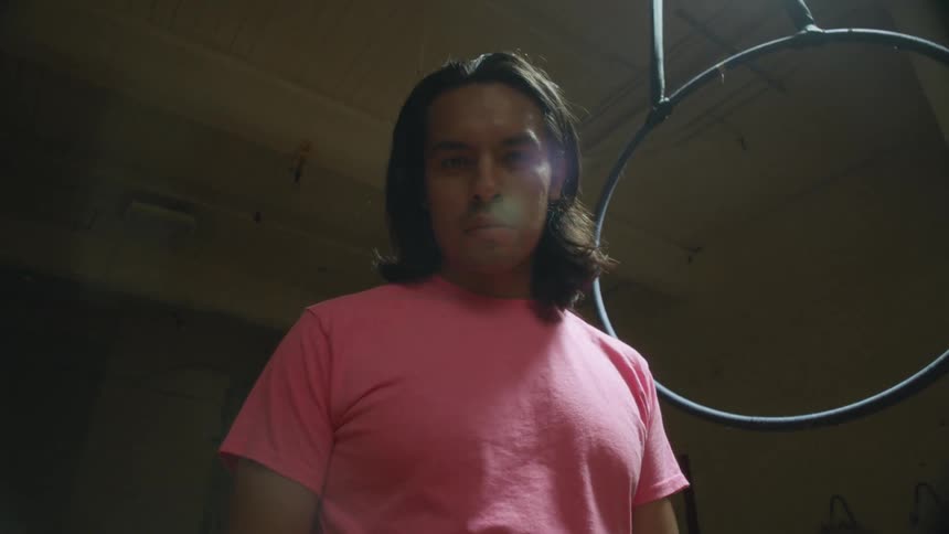 A man is standing in a room next to a metal ring