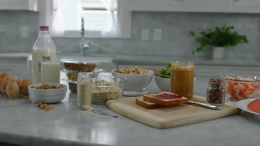 A buffet style layout of lunch food on a marble counter top in a residential kitchen in the daytime