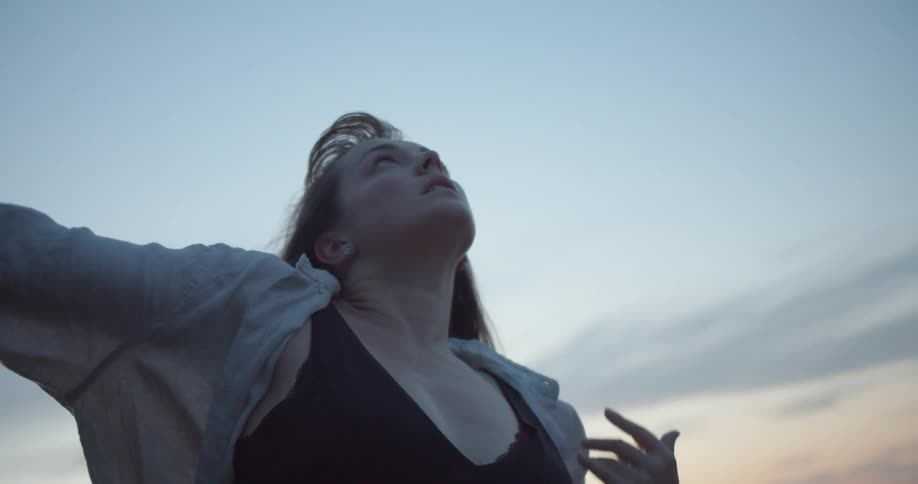 A woman is outside performing tai chi movements