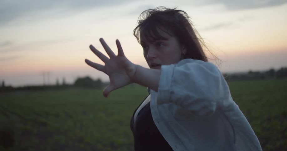 A woman performs a modern dance in an open field