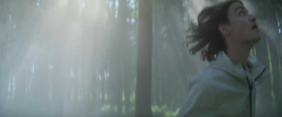 A male runs through a forest