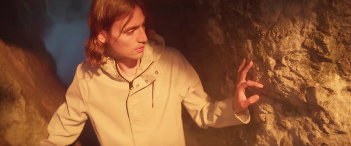 A man is making his way through a cave