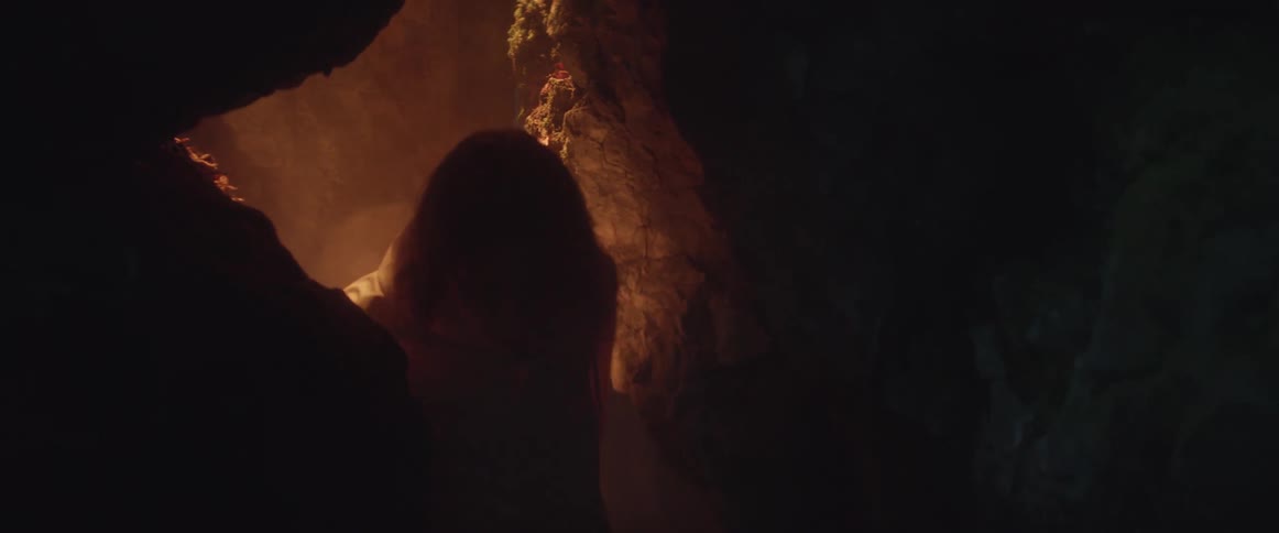 A man walking in a cave with smoke