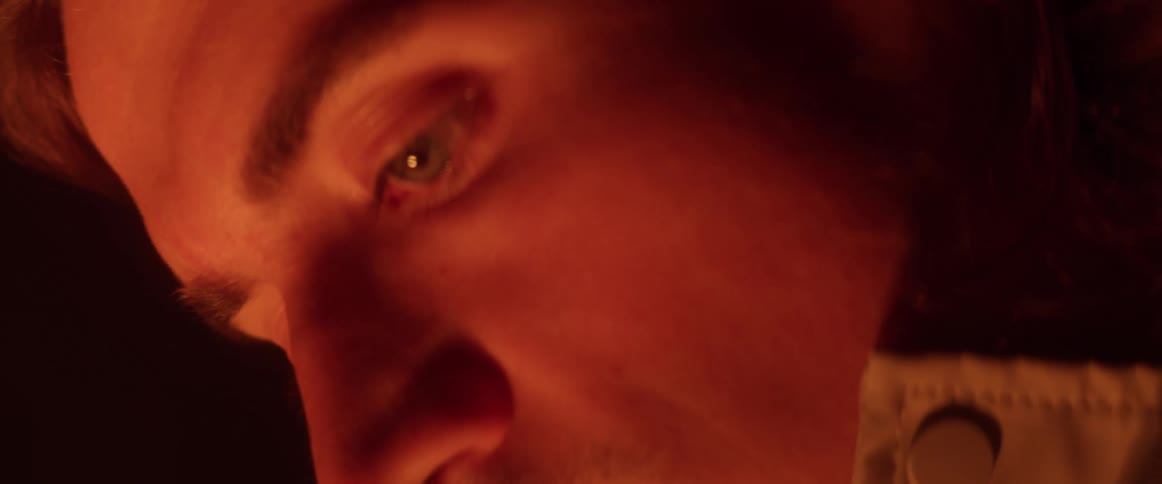 A close up of a mans face in the dark