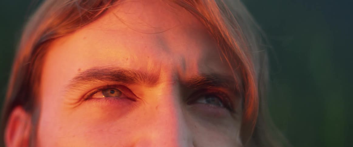 A man looking off into the distance with a light shining on his face