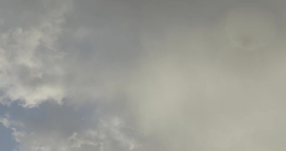 A object falls quickly from a cloudy sky