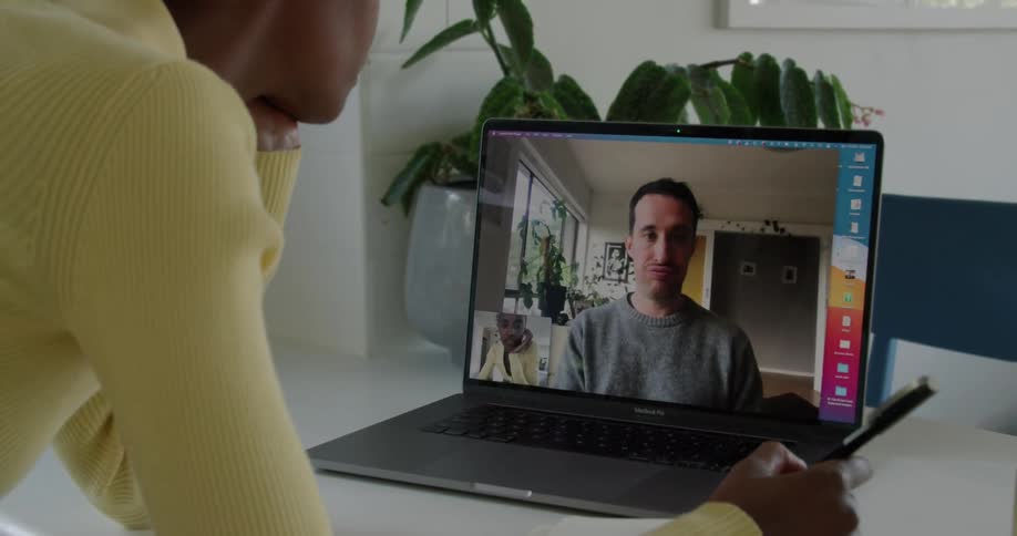A woman is talking to a man through a video call over a laptop